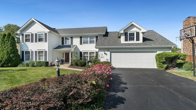 view of front of property featuring a garage, driveway, a front lawn, and a shingled roof