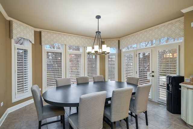 dining room with light tile patterned floors, ornamental molding, baseboards, and a notable chandelier