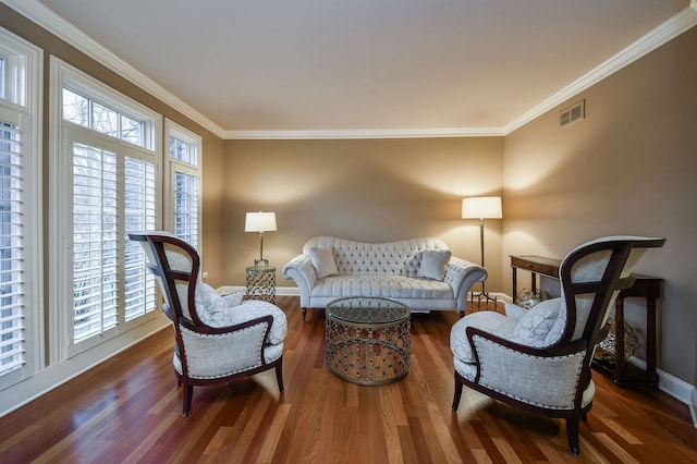 living room featuring a wealth of natural light, visible vents, wood finished floors, and ornamental molding