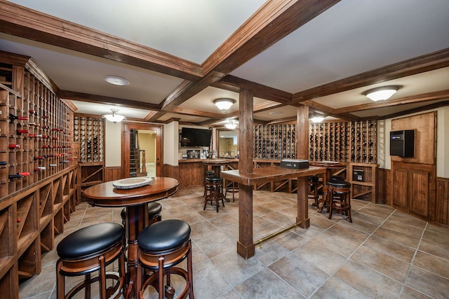 wine room featuring coffered ceiling, wainscoting, beamed ceiling, and wood walls