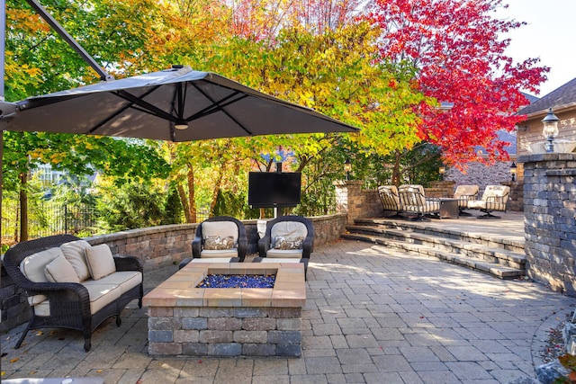 view of patio / terrace with an outdoor living space with a fire pit and fence