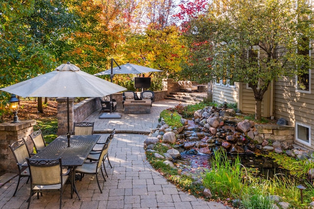 view of patio / terrace with outdoor dining space and an outdoor fire pit