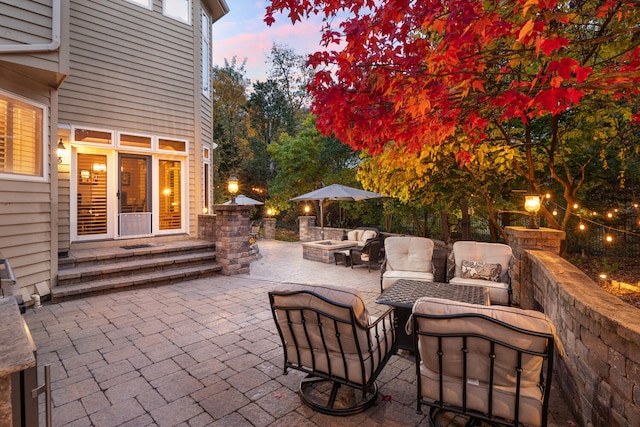 patio terrace at dusk with an outdoor living space with a fire pit