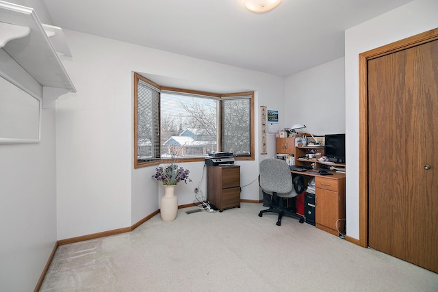 office area featuring baseboards and light colored carpet