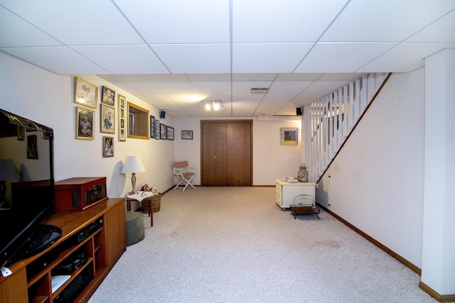 living area with a paneled ceiling, stairway, carpet, and baseboards