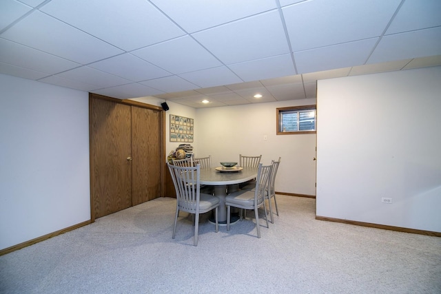 carpeted dining area with a paneled ceiling, baseboards, and recessed lighting