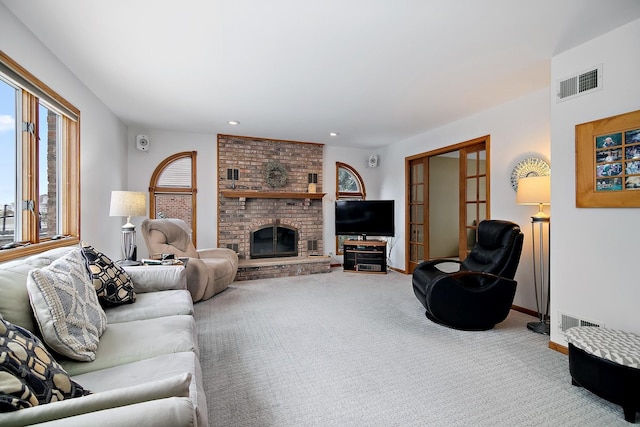 carpeted living area featuring recessed lighting, a fireplace, visible vents, and baseboards