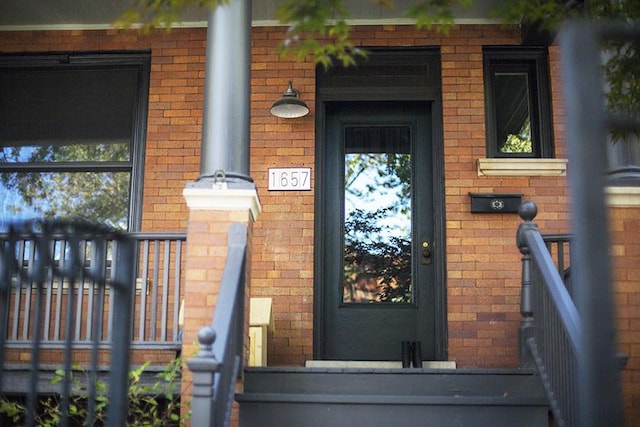 doorway to property with brick siding