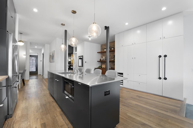 kitchen featuring dark cabinets, built in microwave, a sink, and modern cabinets