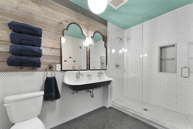 full bath featuring toilet, a sink, a shower stall, and visible vents