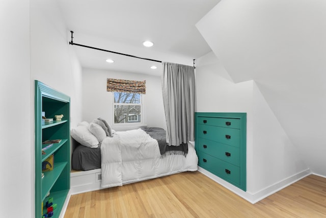 bedroom with baseboards, wood finished floors, and recessed lighting