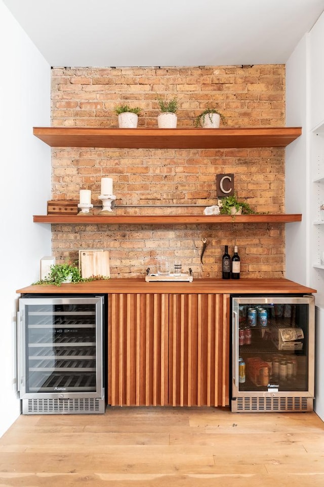 bar with a dry bar, beverage cooler, and wood finished floors