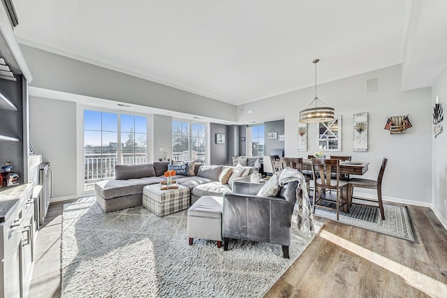 living area with ornamental molding, baseboards, and wood finished floors