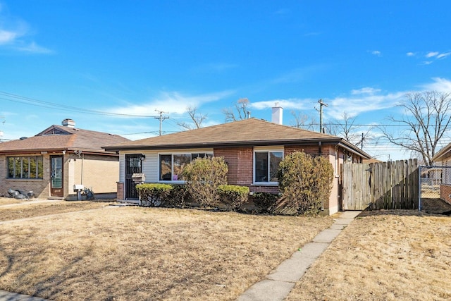 single story home featuring brick siding, fence, and a chimney