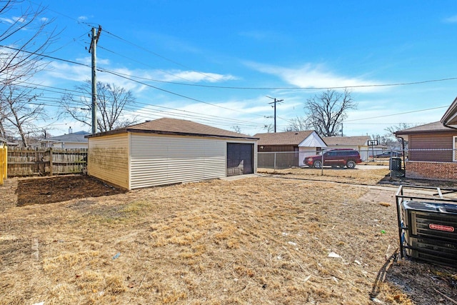 view of yard with a garage, fence, and an outdoor structure