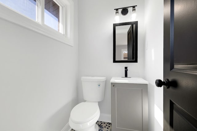 bathroom with toilet, baseboards, and vanity