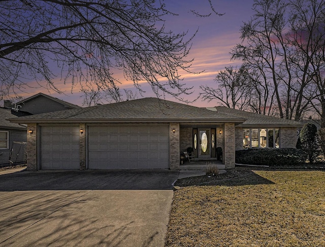 view of front of home with an attached garage, concrete driveway, and brick siding