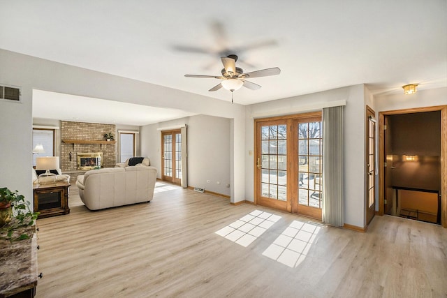 living room with plenty of natural light, a fireplace, wood finished floors, and visible vents