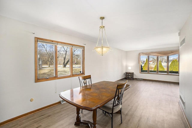 dining space featuring baseboards, visible vents, and light wood-style floors