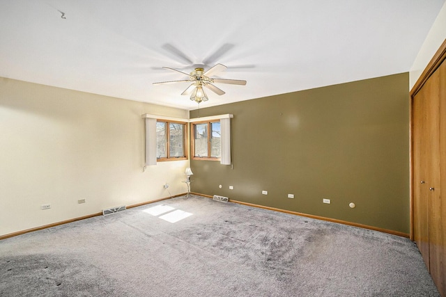 empty room with a ceiling fan, baseboards, visible vents, and carpet flooring