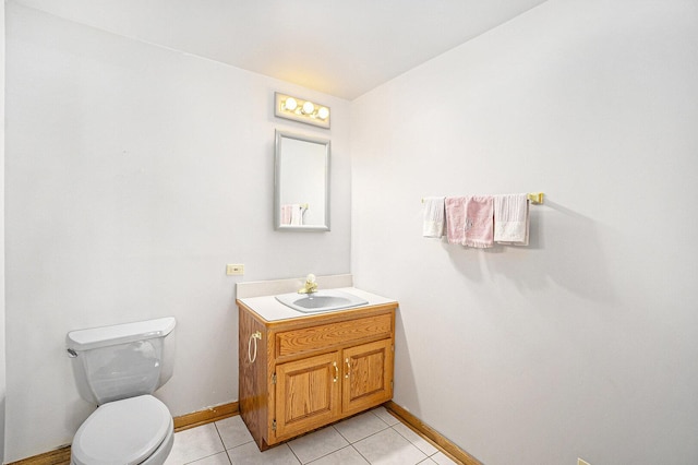 bathroom with toilet, vanity, baseboards, and tile patterned floors