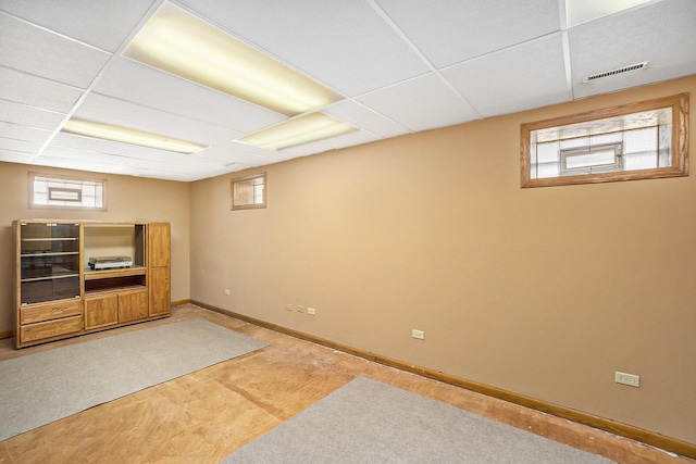 interior space with visible vents, a paneled ceiling, and baseboards