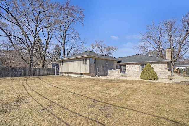 view of property exterior featuring fence, a chimney, and a lawn