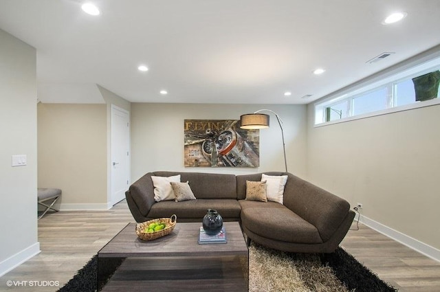 living room featuring baseboards, light wood-style flooring, and recessed lighting