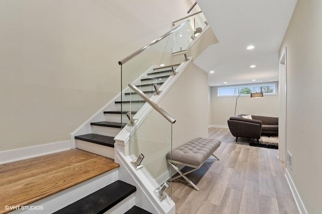 stairway with visible vents, baseboards, wood finished floors, and recessed lighting