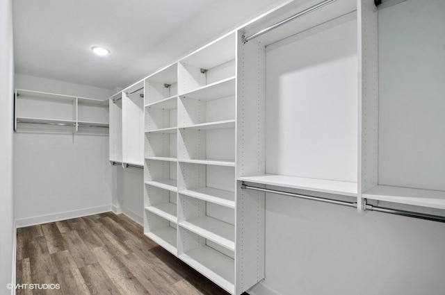 walk in closet with wood finished floors