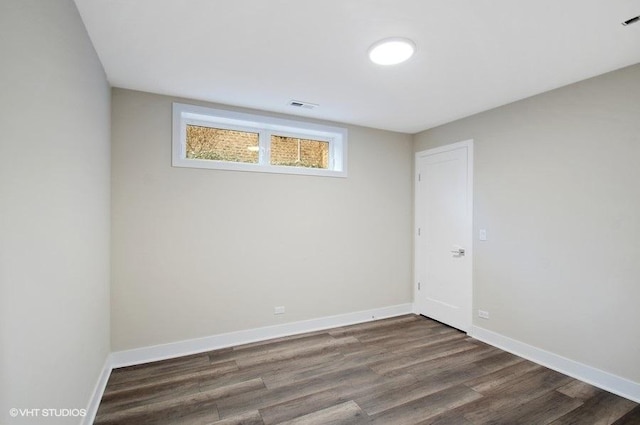 unfurnished room featuring visible vents, baseboards, and wood finished floors