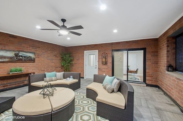 living area featuring brick wall, a ceiling fan, and recessed lighting