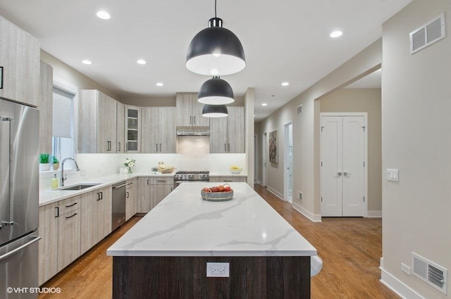 kitchen with stainless steel appliances, visible vents, a sink, and modern cabinets