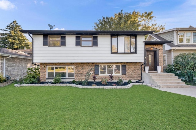 bi-level home with a front lawn and brick siding