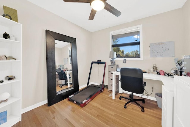 office space with built in features, light wood-style flooring, baseboards, and a ceiling fan