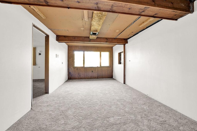 spare room with beam ceiling and carpet flooring