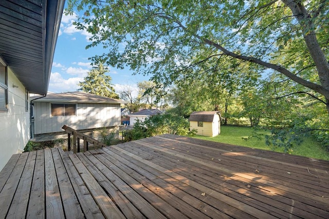 deck with a storage shed, a lawn, and an outdoor structure