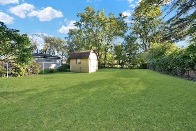 view of yard with an outbuilding, a storage unit, and a fenced backyard