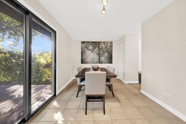 dining space featuring light tile patterned floors and baseboards