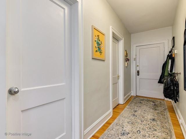 doorway with light wood-style flooring and baseboards