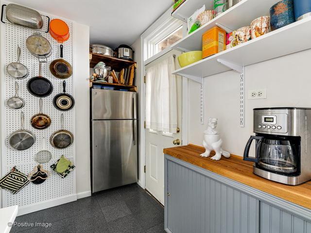 kitchen with butcher block countertops, freestanding refrigerator, baseboards, and open shelves