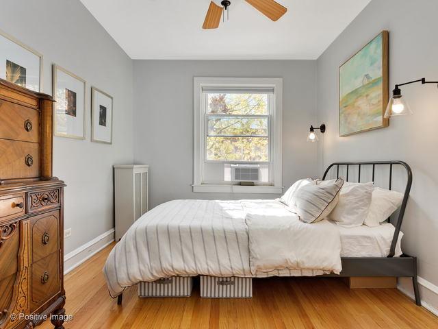 bedroom featuring cooling unit, wood finished floors, and baseboards