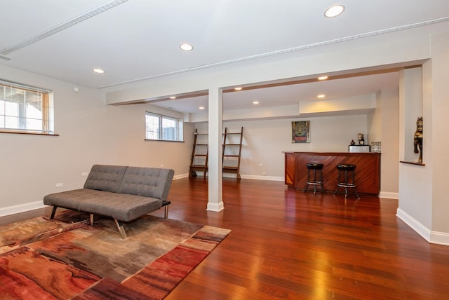 living area featuring recessed lighting, baseboards, a bar, and wood finished floors