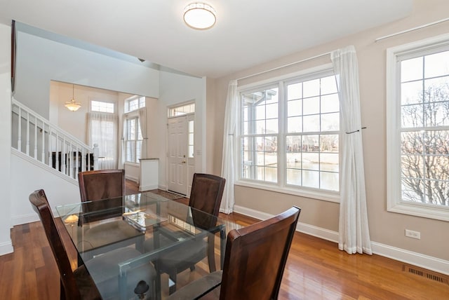 dining area with visible vents, a healthy amount of sunlight, and wood finished floors