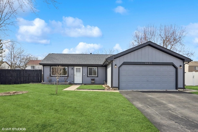 ranch-style house with aphalt driveway, an attached garage, fence, and a front yard