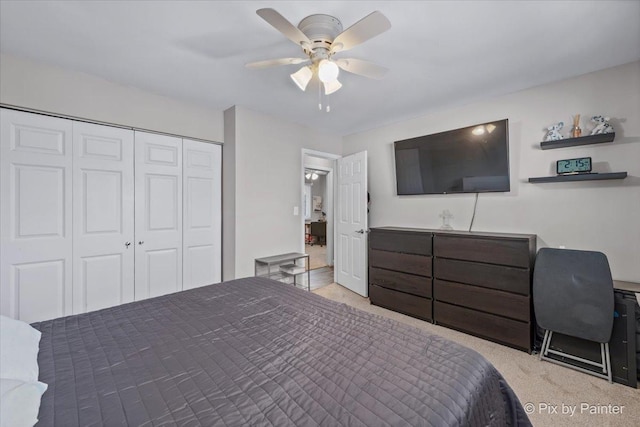 bedroom with a ceiling fan, a closet, and light carpet