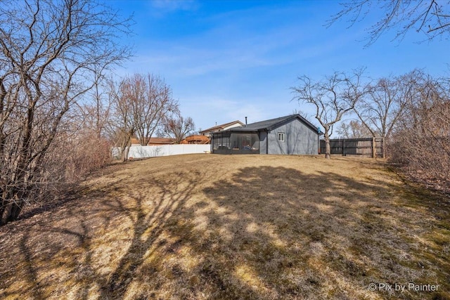 view of yard with fence and a sunroom