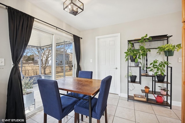 dining space featuring light tile patterned floors and baseboards