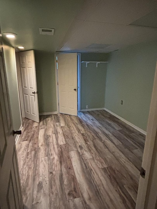 unfurnished bedroom featuring wood finished floors, visible vents, and baseboards