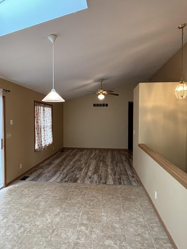 spare room featuring a ceiling fan, lofted ceiling, visible vents, and wood finished floors